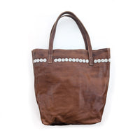 Brown leather tote bag with white beaded circles along the top.
