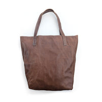 Plain brown leather tote bag on a white background