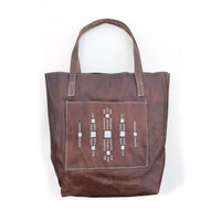Leather tote bag with square front pocket and white geometric beaded design.