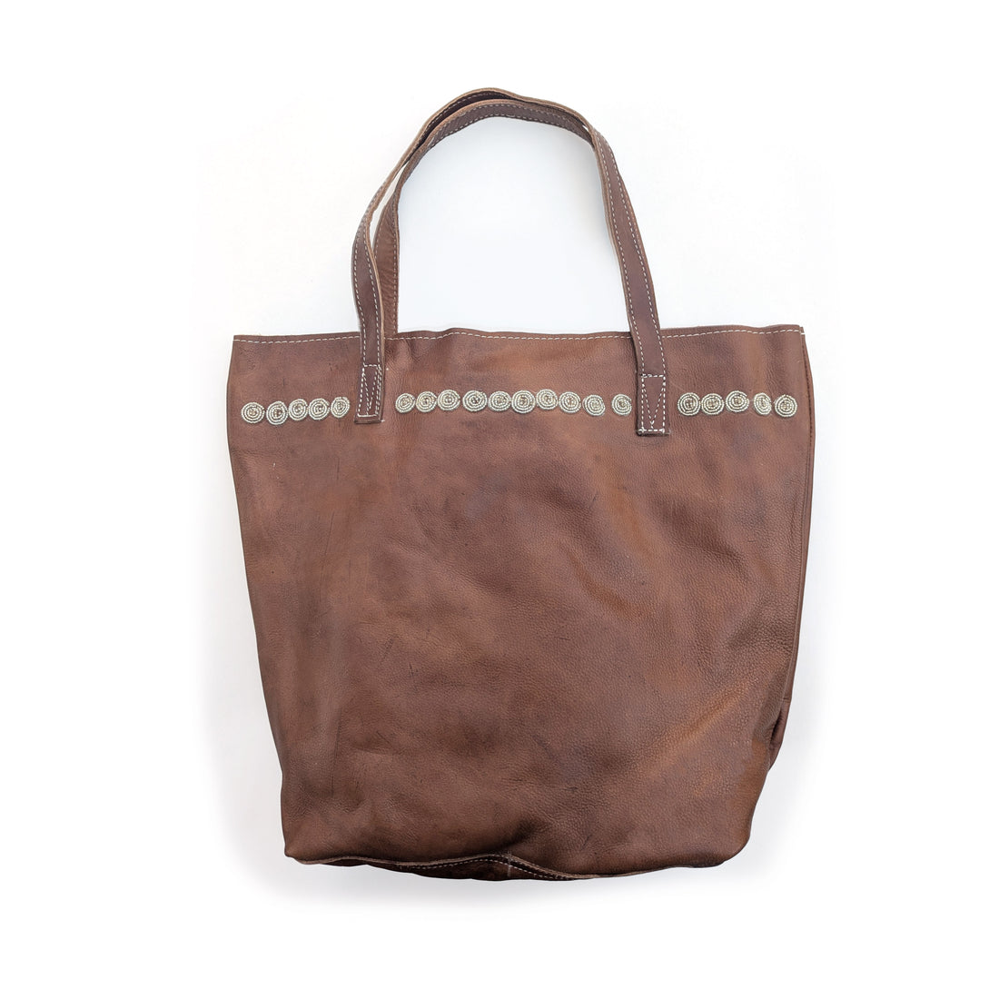 Brown leather tote bag with silver beaded circles along the top.
