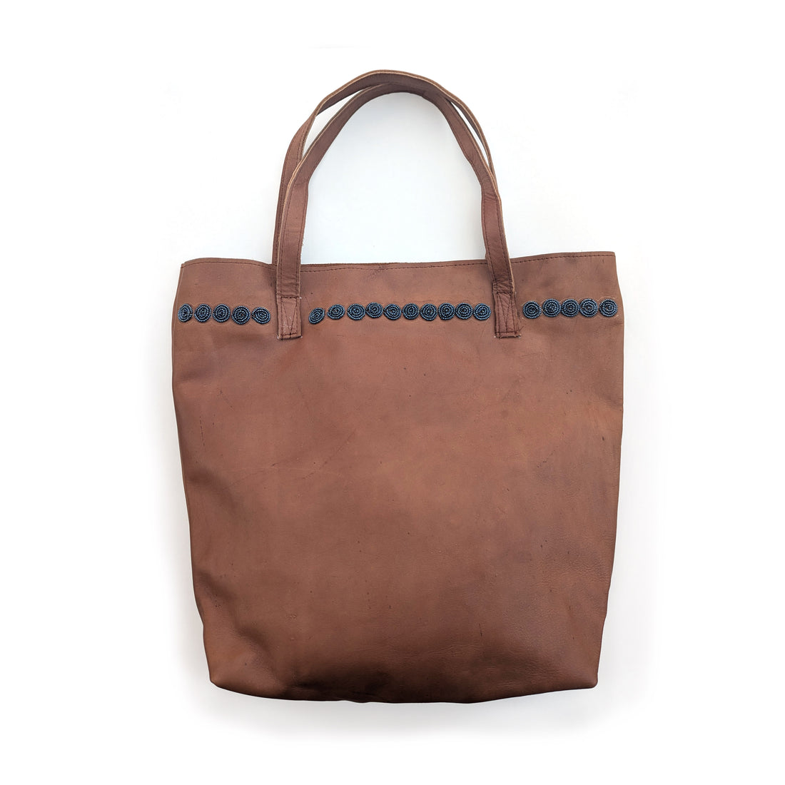Brown leather tote bag with slate beaded circles along the top.