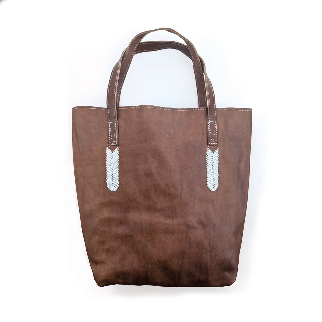 Brown tote bag with white beaded accents on a white background