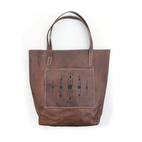 Leather tote bag with square front pocket and slate geometric beaded design.